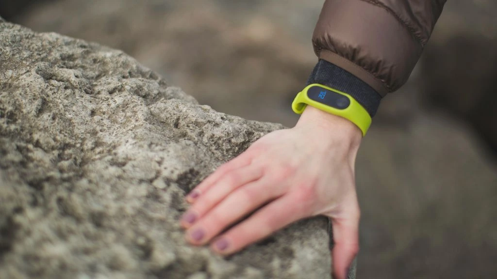 Documentary photograph of a wearable biometric device on a bedside surface.